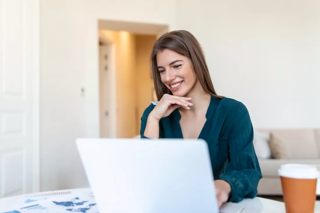 Une jeune femme cherche un emploi sur son ordinateur portable