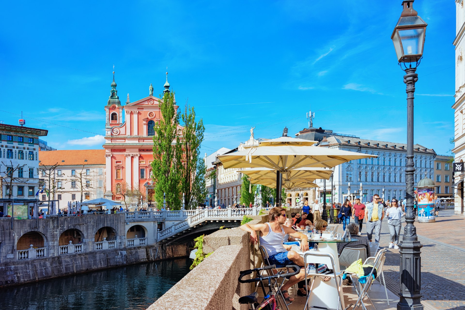 Personnes à la terrasse d’un café sur le Triple Pont, au bord de la Ljubljanica, à Ljubljana